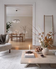 a living room filled with furniture and a candle on top of a wooden coffee table