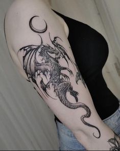 a woman's arm with a dragon tattoo on the left side of her body