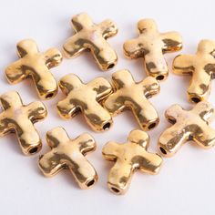 several gold colored crosses are shown on a white surface