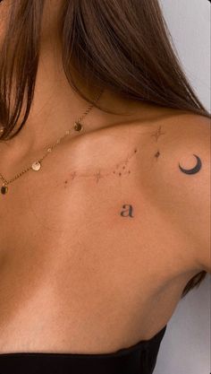 the back of a woman's shoulder with stars and moon tattoos on her chest