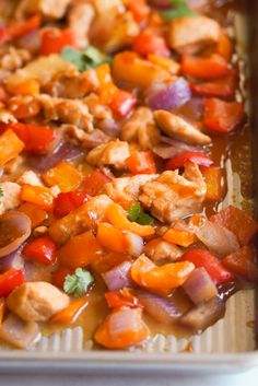 a pan filled with chicken and vegetables on top of a table