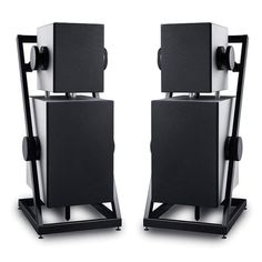 two black and white speakers sitting next to each other on top of metal stand legs