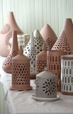 a table topped with lots of pink vases filled with different types of candlesticks