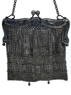 an old metal purse with chains hanging from it's sides on a white background