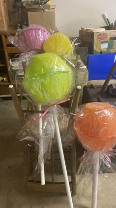 two large lollipops wrapped in plastic sitting on top of a wooden chair