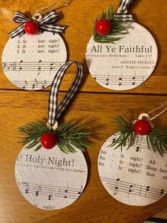 three christmas ornaments hanging on a table with sheet music notes and holly wreaths attached to them