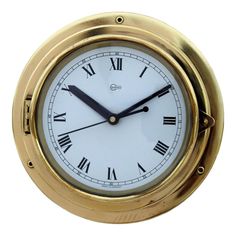 a gold clock with roman numerals on the face