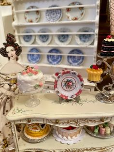 there are many plates and cakes on the shelf in this room, including one with an angel figurine