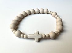 "This gorgeous rosary bracelet is made with 8mm and 4mm petrified wood beads and finished with a 12mmx15mm howlite cross. Strung on heavy-duty stretch cording. The bracelet size is adjusted by adding or removing the 4mm petrified wood spacer beads. Please measure your wrist with a fabric tape measure (The metal ones don't bend well making them inaccurate for wrist measuring. If you don't have a fabric tape measure, use a piece of string. Snugly, but comfortably, wrap it around your wrist and then measure that length on a ruler.) Then add .5\" to 1\" to that measurement to determine the bracelet size. Sizing example: If your wrist measures 7\" then a size 7.5\" rosary bracelet would be right if you like a snugger fit--it will sit right on your wrist bone. If you want it to fit a bit looser White Stretch Bracelet With Round Wooden Beads, White Bracelets With Round Wooden Beads, White Spiritual Rosary Bracelet With 8mm Beads, Spiritual White Rosary Bracelet With Round Beads, White Stretch Bracelet With Wooden Beads For Gift, White Wooden Beads Stretch Bracelet As Gift, White Wooden Beads Stretch Bracelet Gift, White Wooden Beads Rosary As Gift, White Rosary With Wooden Beads As Gift