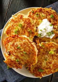 some food is on a white plate with green onions and sour cream in the middle