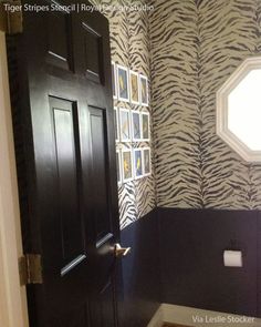 a bathroom with zebra print wallpaper and wooden door