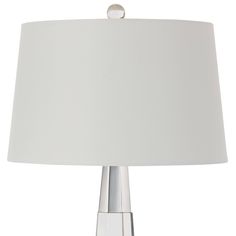 a table lamp with a white shade on the base and a silver ball at the top