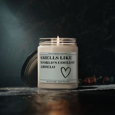 a candle is sitting on a table with the words smells like world's coolest adelo