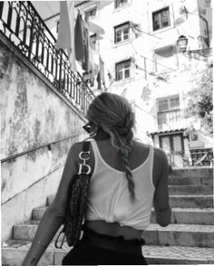 a woman walking down some stairs with her hand in her pocket