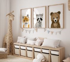 three pictures of animals hanging on the wall in a child's room with storage bins