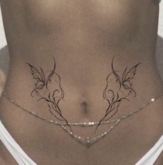 a woman's stomach with tattoos on the side and an attached chain around her waist