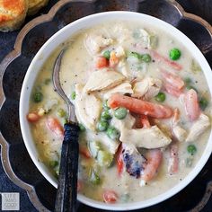 a bowl of chicken and vegetable soup with a spoon