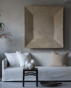 a living room with a white couch and two vases sitting on the coffee table