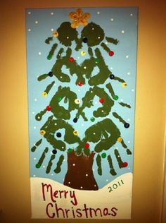 a christmas tree made out of handprints is hanging on the wall in front of a door