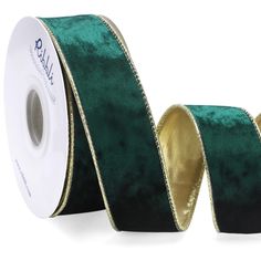 a roll of green velvet ribbon with gold foil on the side and two rolls of black satin