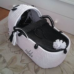 a crocheted white and black baby carriage