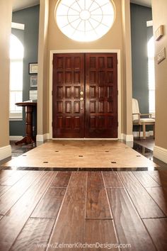 an empty room with two doors and a round window in the center is seen from the floor