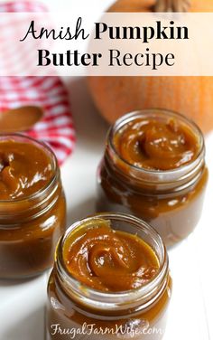 two jars filled with pumpkin butter sitting on top of a table