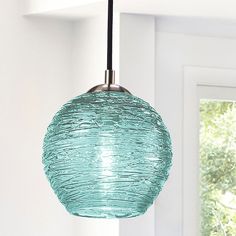 a glass light hanging from a ceiling in a room