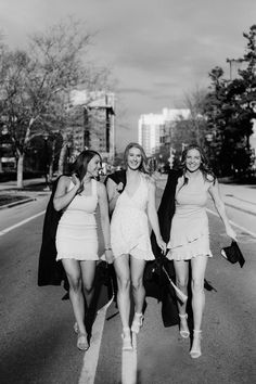 three women walking down the street in dresses