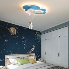 a bedroom decorated in blue and white with space themed wallpaper