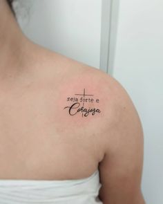 a woman with a cross tattoo on her shoulder and the words costa written in cursive ink