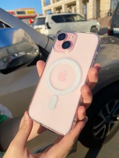 a person holding an iphone case in front of a car with the camera on it