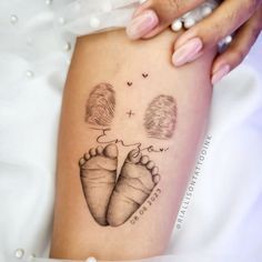 a woman's foot with two baby feet in the shape of hearts on her leg