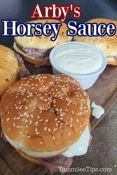 a close up of a sandwich on a tray with ranch dressing and bagels in the background