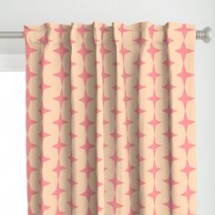 a pink and beige curtain with an abstract design on the top, in front of a window