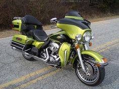 a green motorcycle is parked on the side of the road