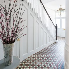 a vase filled with flowers sitting on top of a table next to a stair case