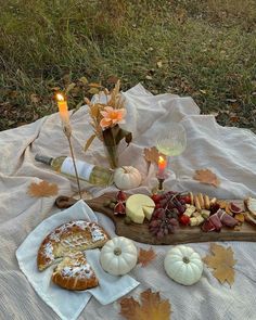 a table topped with food and candles on top of a blanket