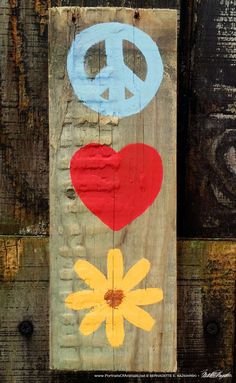 a wooden sign with peace, love and daisies painted on it