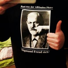 a person holding up a t - shirt with an image of a man pointing at the camera