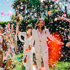 a man and woman are walking through confetti