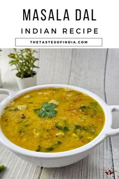 a white bowl filled with yellow soup and garnished with cilantro leaves