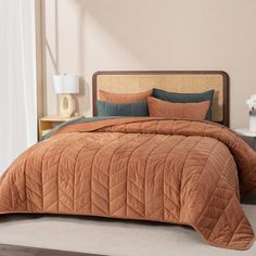 a bed with a brown comforter and pillows