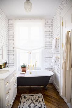 a bathroom with a tub, sink and window in the corner is featured on instagram