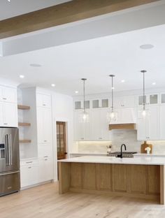 a kitchen with white cabinets and wood floors is shown on the phone screen in this image