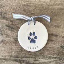 a ceramic ornament with a dog's paw and name on the front