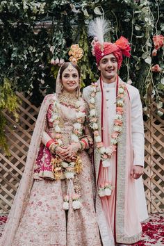 two people standing next to each other in wedding outfits