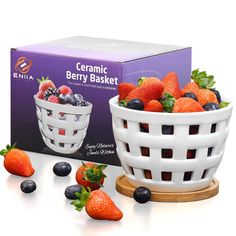 a white ceramic bowl filled with berries next to a box of berry basket