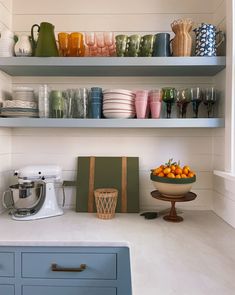 the shelves in the kitchen are filled with dishes and cups