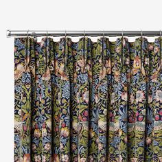 the curtain is open and has an intricate floral pattern in blue, green, yellow and red